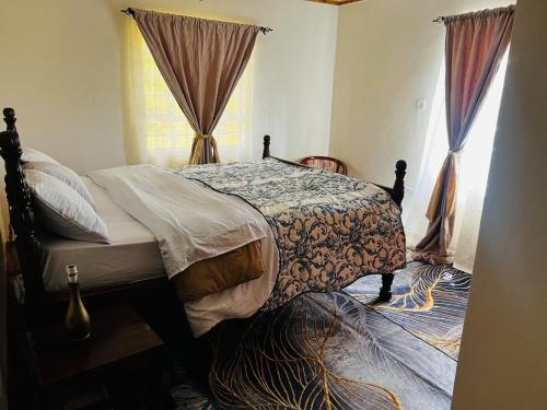 a bedroom with a bed and a window with curtains at KFarm house in Kijabe