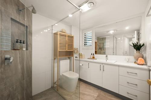 a bathroom with a toilet and a sink and a shower at Classic Coastal Escape - 1 Bedroom Ocean Views in Maroochydore