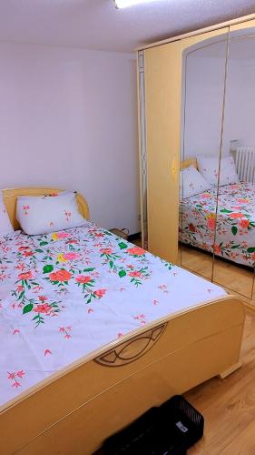a bedroom with a bed with flowers on it at Le séjour in Champigny-sur-Marne