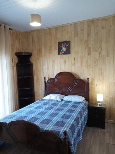 a bedroom with a bed with a blue comforter at Lombada Villa Comfort in Ponta Delgada