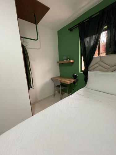 a bedroom with a bed and a table and a window at Olivo House Casa Hotel in Envigado