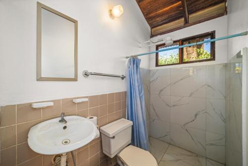 a bathroom with a sink and a toilet and a shower at Hotel Hibiscus in Playa Junquillal