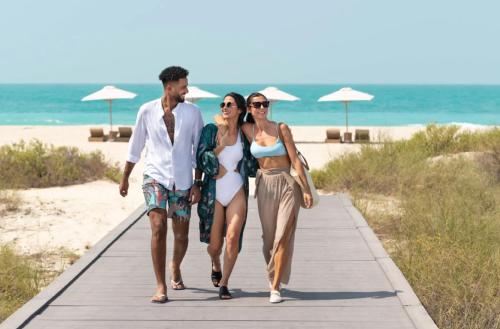 a group of people walking down a boardwalk at the beach at Grand Hyatt Cancun Beach Resort in Cancún