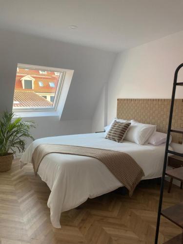 a bedroom with a large bed with a window at Salitre - Boa Onda in Cee