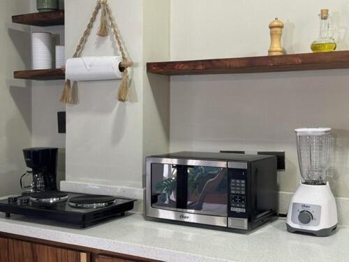 a kitchen counter with a microwave and a blender at Litos Hotel y Restaurante in Playa San Blas