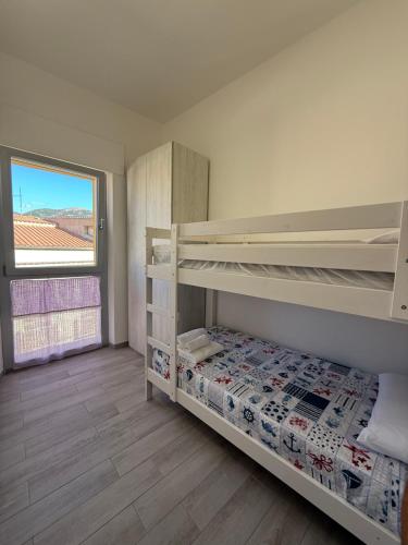 a bedroom with two bunk beds and a window at Alba&Tramonto in Arbus