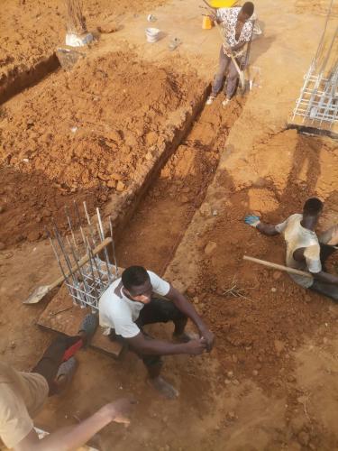 Eine Gruppe Bauarbeiter, die im Dreck arbeiten in der Unterkunft Kaffolo in Abidjan