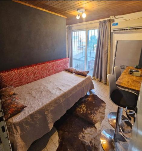 a bedroom with a bed and a table and a window at Departamento cómodo y renovado a pocas cuadras del parque mitre! in Corrientes
