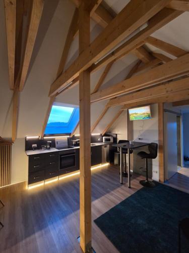 an attic office with a desk and a table at Moderne Dachgeschosswohnung am Wald in Großnaundorf