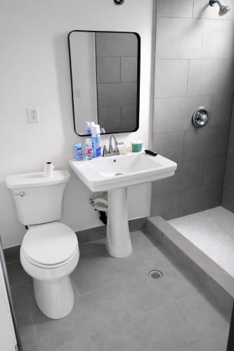 a bathroom with a toilet and a sink and a mirror at Hoover Stay Close to Bus Routes in Los Angeles