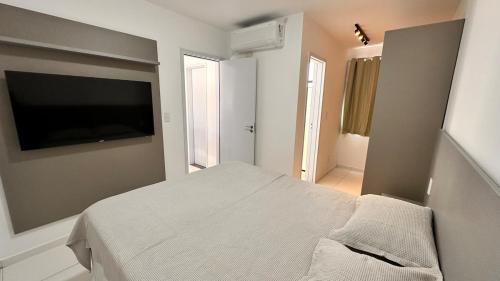 a bedroom with a bed and a flat screen tv at Dona Olivia Universidade 16 in Vitória da Conquista