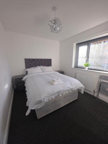 a bedroom with a white bed and a window at Private Cosy Double Bedroom, extremely close to city centre in Manchester