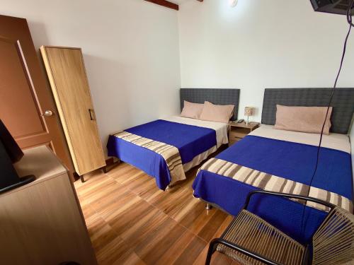 a hotel room with two beds and a television at Huacachina Desert II in Ica