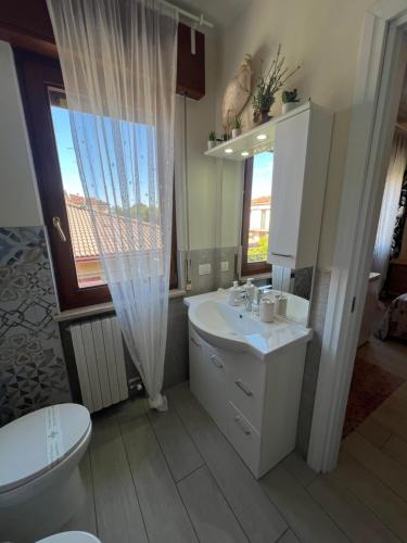 a bathroom with a sink and a toilet and a window at Monolocale Pink Borgo Roma GB Rossi friendly Verona in Verona