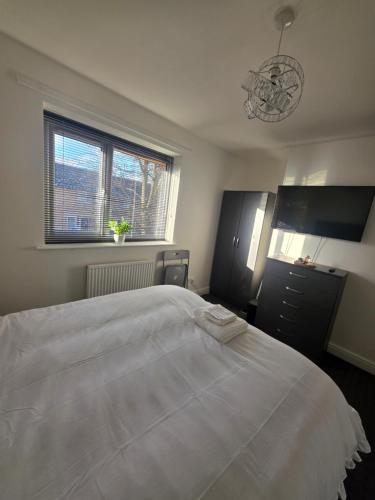 a bedroom with a large white bed and a window at Private Cosy Double Bedroom, extremely close to city centre in Manchester