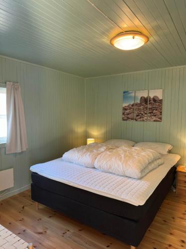 a large bed in a room with a ceiling at Nusfjord Ocean View Rorbu 19 in Ramberg