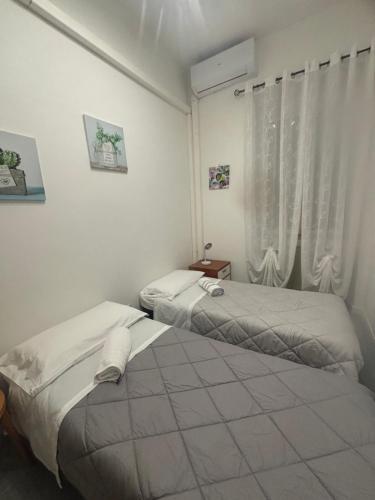 two beds in a room with a window at Tower casa vacanze 1 in Anzio