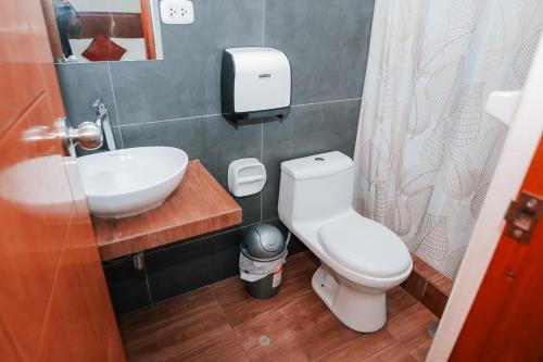 a bathroom with a white toilet and a sink at HOTEL LA PALMERA DE ORO in Tarapoto