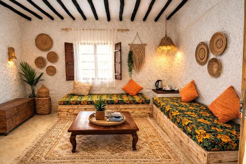 a living room with a couch and a table at HA Beach Breeze in Jambiani