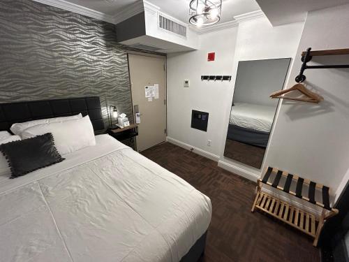 a bedroom with a large white bed and a mirror at Hotel Richland LES in New York