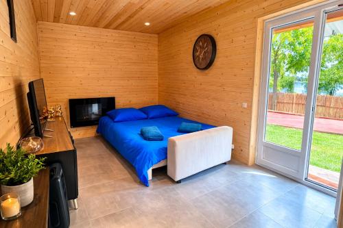a bedroom with a bed and a tv in a room at Le chalet au bord de seine in Les Mousseaux