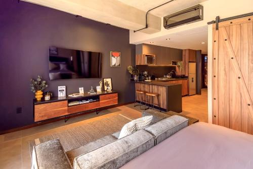 a living room with a couch and a kitchen at Atena Urban Living in Guadalajara