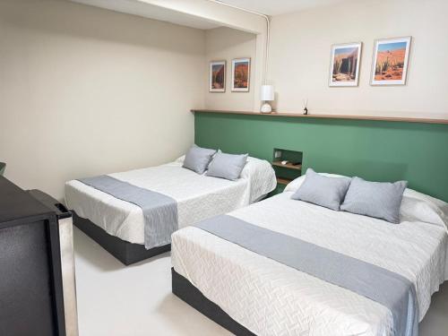 a room with two beds and a television at Suite 01 Montenegro in Monterrey
