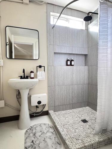 a bathroom with a sink and a shower with a mirror at Suite 02 Montenegro Cerca de Consulado in Monterrey