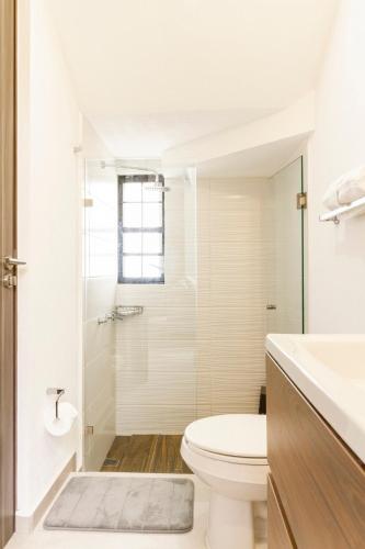 a white bathroom with a toilet and a shower at Quiet and comfortable space in Aguascalientes