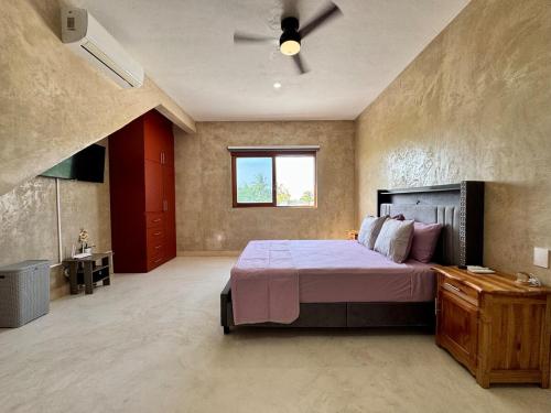a bedroom with a large bed and a window at Panoramic Ocean Views - Villa Home Chelem in Chelem