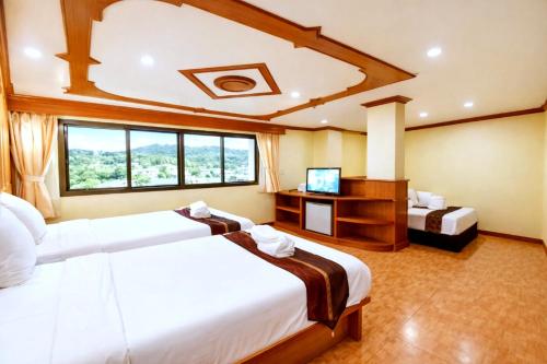a hotel room with two beds and a television at Tiger Complex Patong in Patong Beach