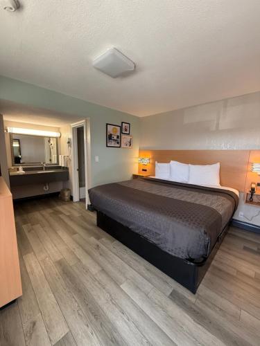 a bedroom with a large bed and a bathroom at Americas Best Value Inn Ponca City in Ponca City