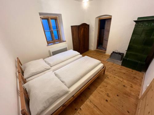 a room with a bed with white sheets and a window at WildAlps-Apartments in Wildalpen