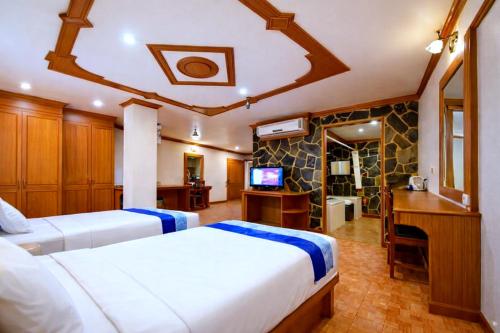 a hotel room with two beds and a television at Tiger Complex Patong in Patong Beach