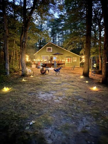 a barn with a table and benches in front of it at UPTA CAMP LIMIT 8 cabin in West Baldwin