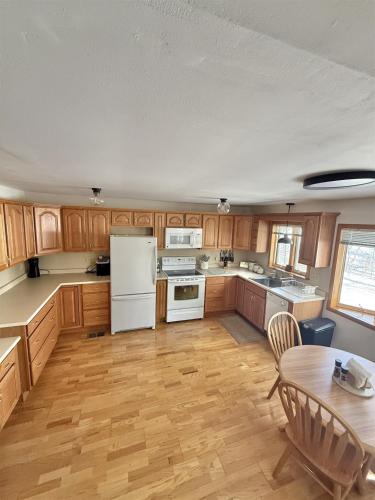 a kitchen with wooden cabinets and a white refrigerator at UPTA CAMP LIMIT 8 cabin in West Baldwin