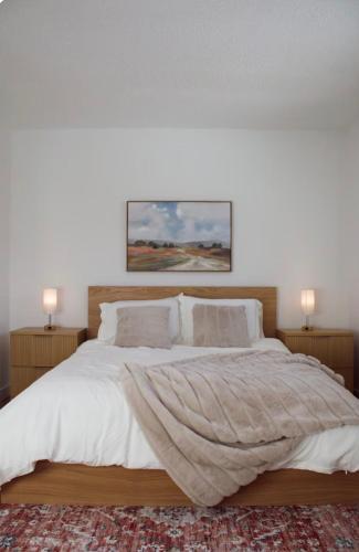 a bedroom with a large bed with white sheets and pillows at Brùn House in Fort Saint John
