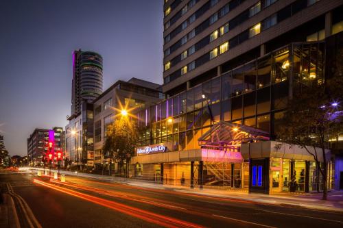 a city street at night with buildings and street lights at Hilton Leeds City in Leeds