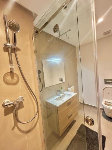 a bathroom with a shower and a sink and a toilet at Spacious Studio with Pool & Wi-Fi in Aïn Harrouda