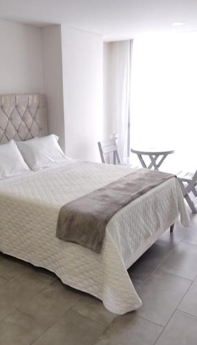 a bedroom with a large bed and a table at Estocolmo in Armenia