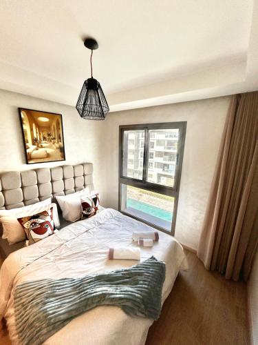 a bedroom with a large bed and a window at Spacious Studio with Pool & Wi-Fi in Aïn Harrouda