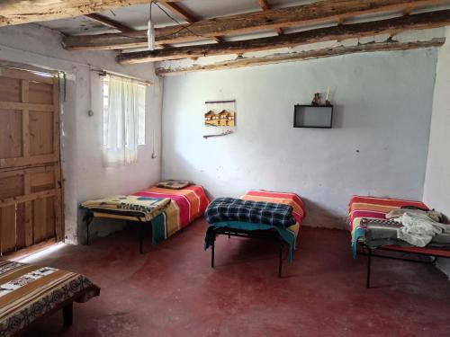 a room with two beds and a tv on the wall at Shendao Eco Salud in Huaripampa