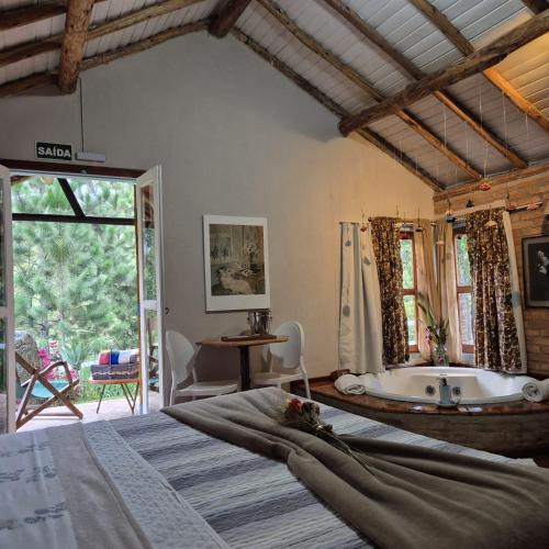 a bedroom with a bed and a bath tub at Pousada Vale Monte Azul in Santo Antônio do Pinhal
