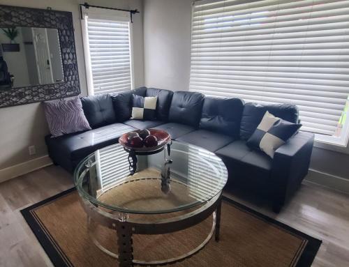 a living room with a blue couch and a glass table at 21 Cozy Home in the Heart of the City in Stockton