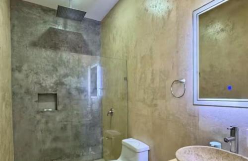 a bathroom with a shower and a toilet and a sink at Panoramic Ocean Views - Villa Home Chelem in Chelem
