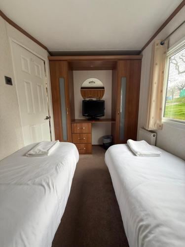 a bedroom with two beds and a window and a tv at 139 The Ridgeway in Cowes