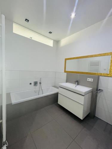 a white bathroom with a tub and a sink at Traum - Apartment mit Spa im Haus in Dortmund