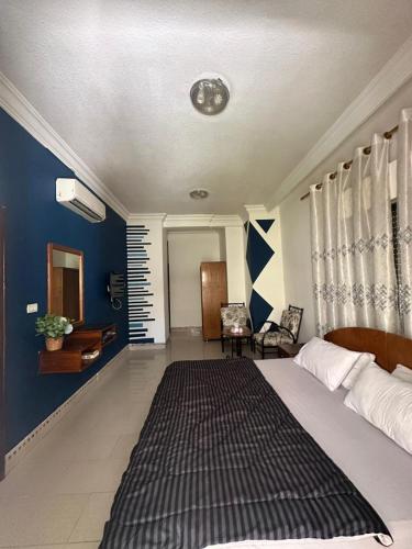 a bedroom with a large bed with a blue wall at Al Majd Hotel in Amman
