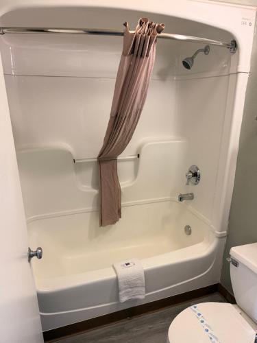 a white bath tub with a shower curtain in a bathroom at Red Carpet Inn And Suites in Maple Shade