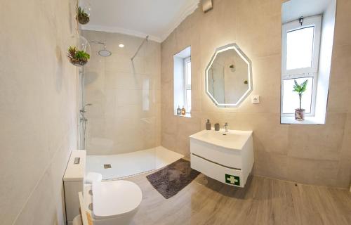 a bathroom with a sink and a toilet and a mirror at Friends Place in Praia da Vitória
